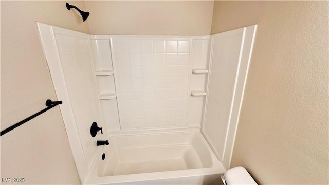 bathroom with a textured wall and toilet