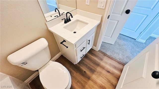 bathroom featuring vanity, wood finished floors, and toilet