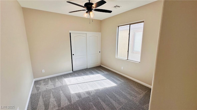 unfurnished bedroom featuring baseboards, visible vents, a ceiling fan, carpet floors, and a closet