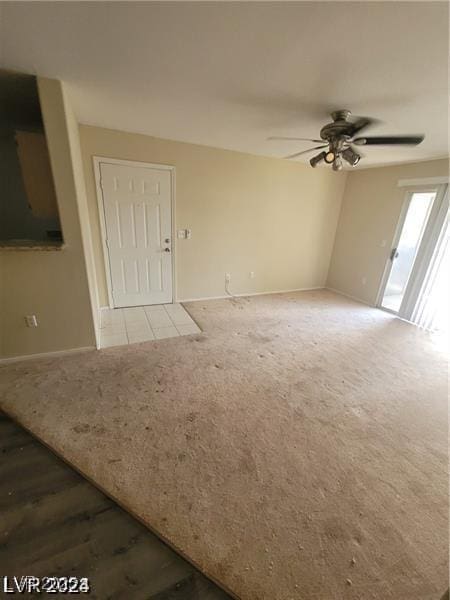 unfurnished living room featuring carpet floors, baseboards, and a ceiling fan