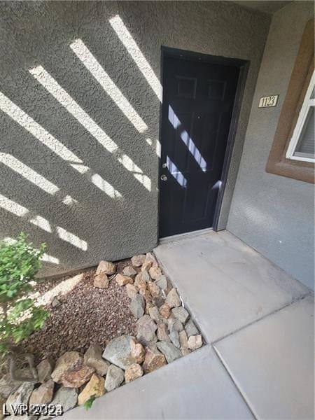 view of exterior entry featuring stucco siding