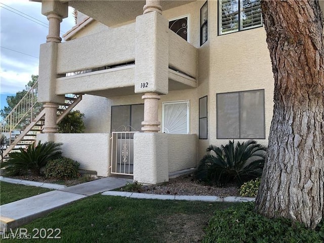 entrance to property featuring a gate and stucco siding