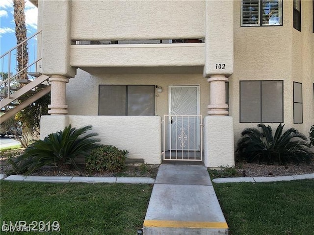 doorway to property featuring stucco siding