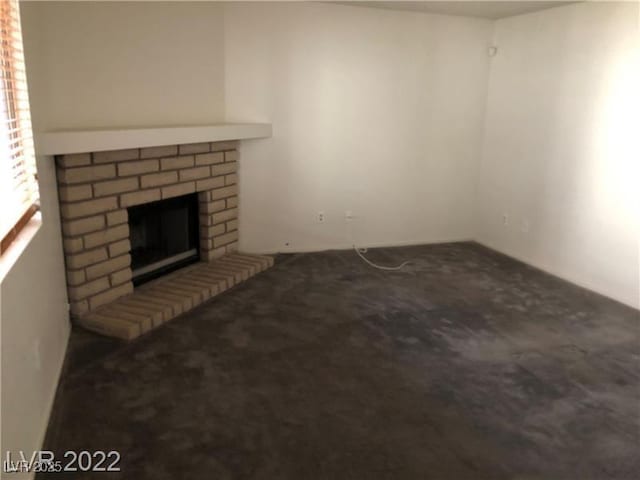 unfurnished living room with a brick fireplace and carpet flooring