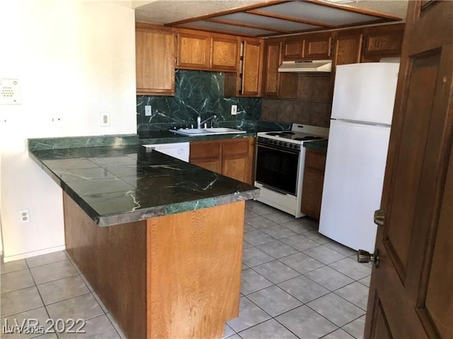 kitchen with range with electric stovetop, freestanding refrigerator, a sink, a peninsula, and under cabinet range hood