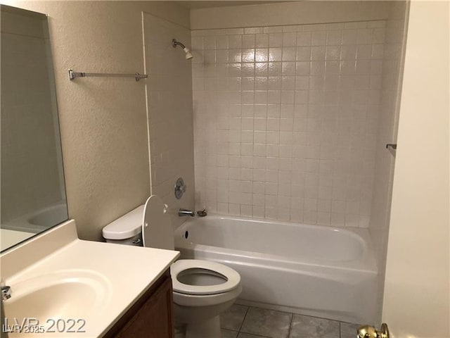 bathroom with a textured wall, tile patterned flooring, toilet, shower / bath combination, and vanity