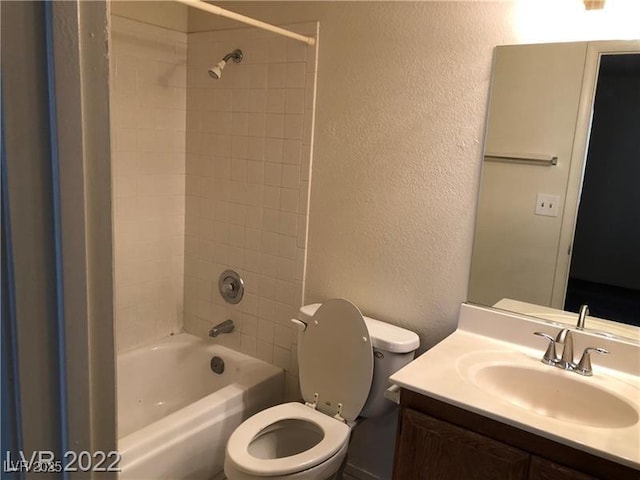 full bath with bathtub / shower combination, a textured wall, vanity, and toilet