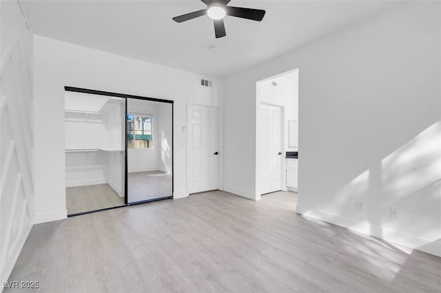 interior space with ceiling fan, light wood-type flooring, visible vents, and baseboards