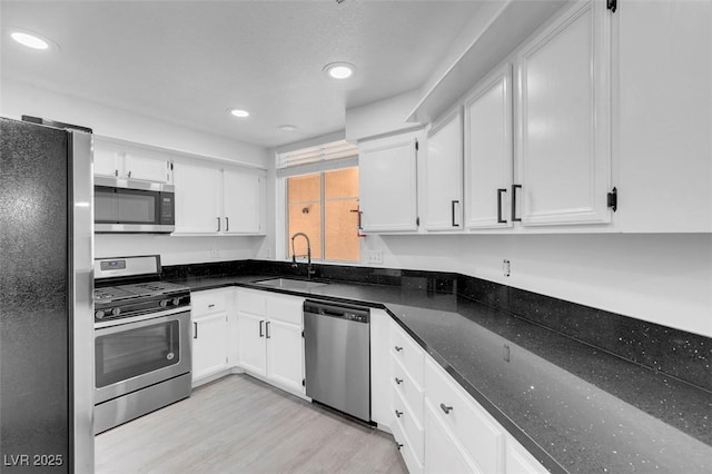 kitchen featuring stainless steel appliances, white cabinetry, and a sink