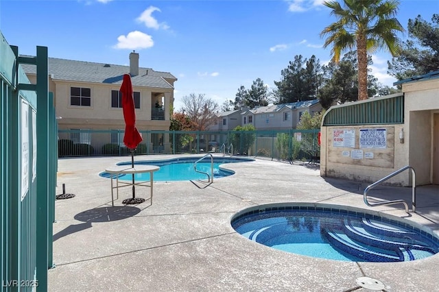 pool with a community hot tub, a patio area, and fence