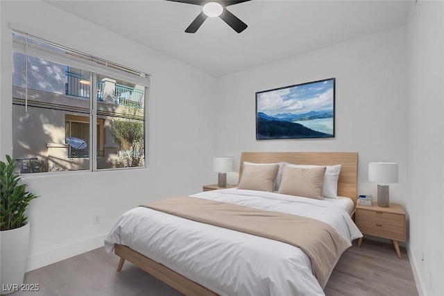 bedroom with a ceiling fan, baseboards, and wood finished floors