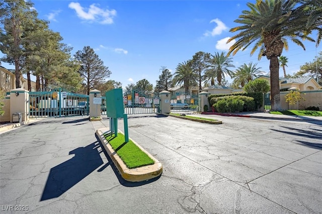 view of street featuring a gate, sidewalks, and a gated entry