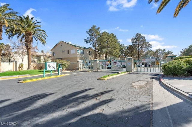 view of road with curbs, a gated entry, and a gate