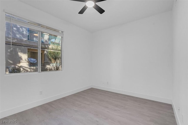 unfurnished room featuring ceiling fan, baseboards, and wood finished floors