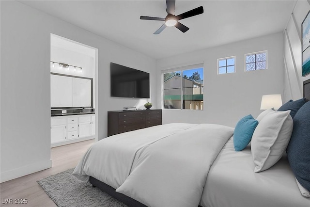 bedroom featuring light wood-type flooring, connected bathroom, a ceiling fan, and baseboards