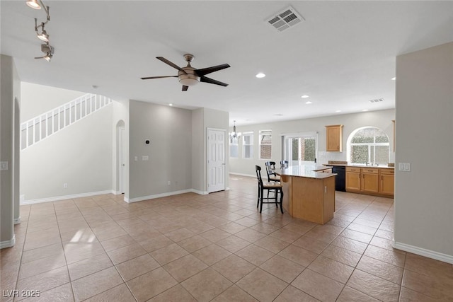 kitchen featuring black dishwasher, visible vents, a kitchen island, a breakfast bar area, and open floor plan