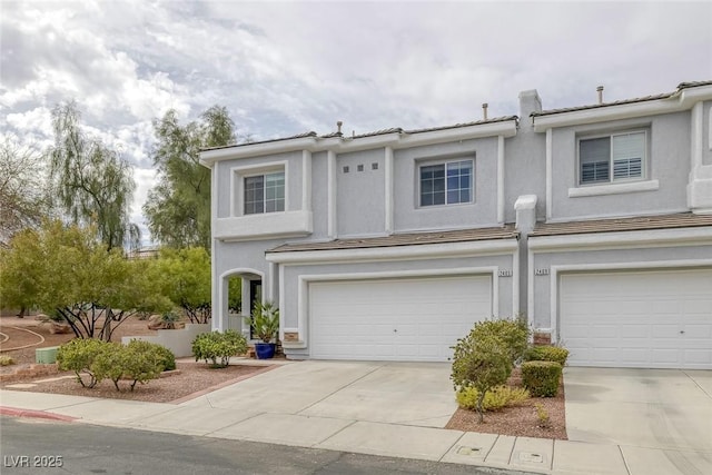 townhome / multi-family property featuring a garage, central air condition unit, concrete driveway, and stucco siding