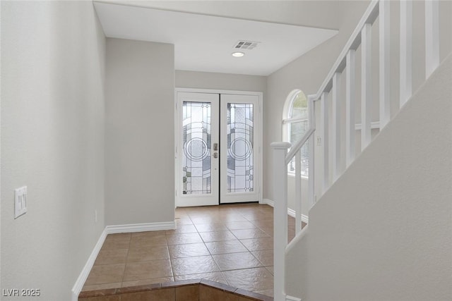 tiled foyer entrance featuring french doors, visible vents, and baseboards