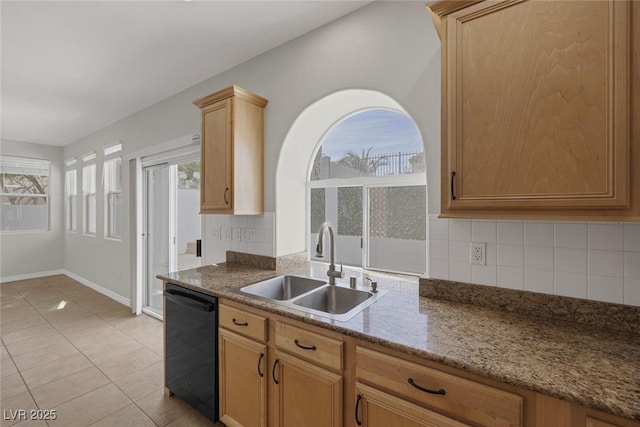 kitchen with light tile patterned floors, a sink, baseboards, backsplash, and dishwasher