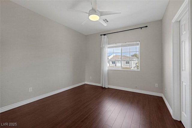 unfurnished room with ceiling fan, visible vents, baseboards, and dark wood finished floors