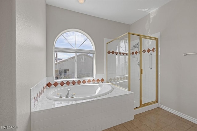 full bath featuring a shower stall, baseboards, and a bath