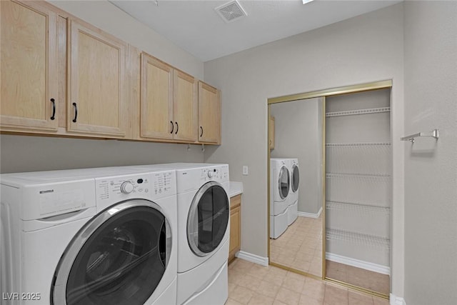 laundry area with washer and dryer, visible vents, cabinet space, and baseboards