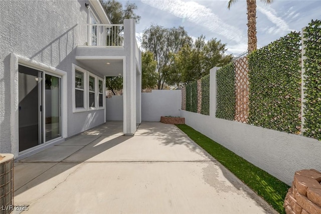 view of patio featuring a balcony, fence, and central AC