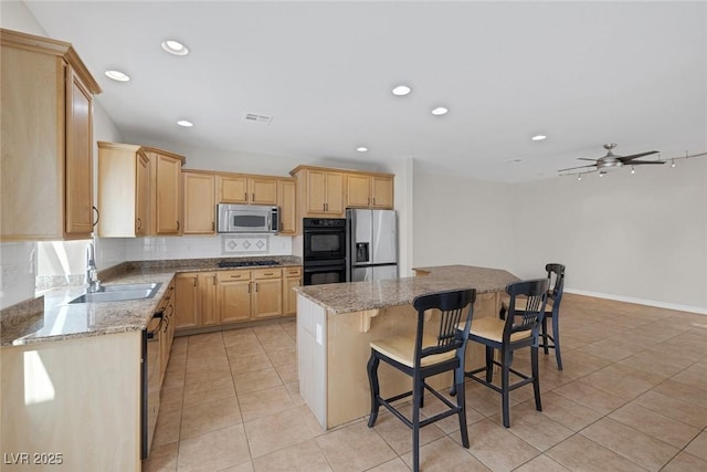 kitchen featuring light tile patterned floors, visible vents, a kitchen island, a kitchen breakfast bar, and stainless steel appliances