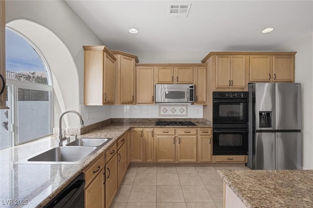 kitchen with light tile patterned floors, a sink, visible vents, black appliances, and tasteful backsplash