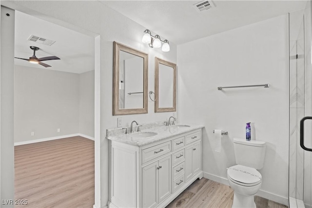 full bath with toilet, wood finished floors, a sink, and visible vents