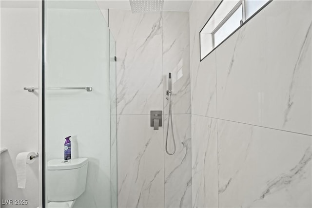 bathroom featuring toilet and a marble finish shower