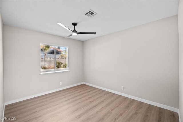 empty room with visible vents, ceiling fan, light wood finished floors, and baseboards