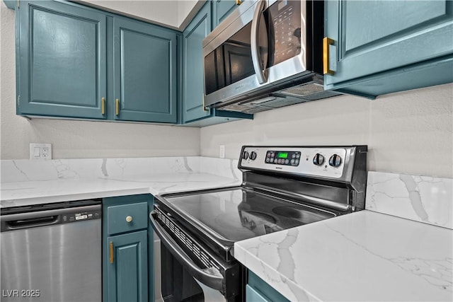 kitchen featuring stainless steel appliances, blue cabinets, and light stone countertops