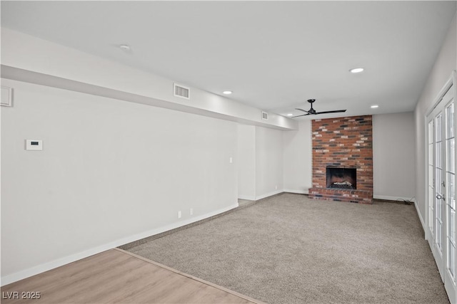 unfurnished living room with a fireplace, visible vents, and baseboards