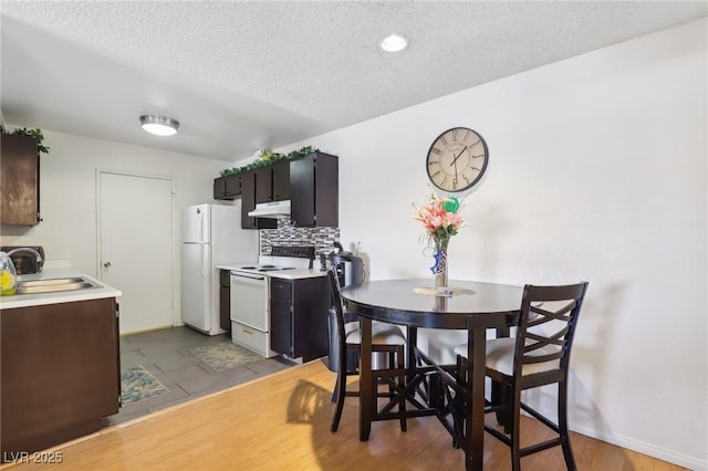 dining area with a textured ceiling and wood finished floors