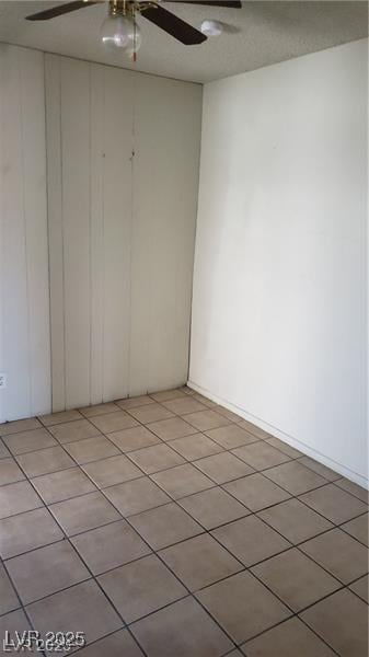 empty room featuring light tile patterned floors and ceiling fan