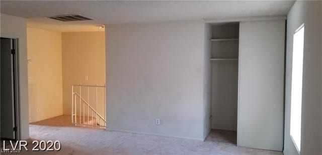 empty room with visible vents and carpet flooring