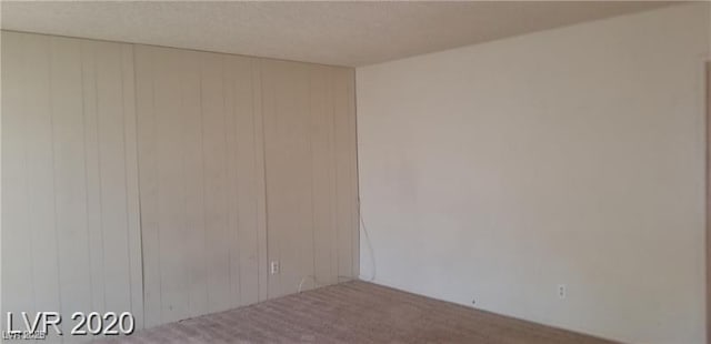 empty room with carpet floors and a textured ceiling