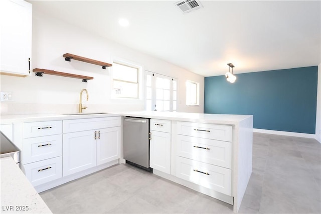 kitchen featuring visible vents, dishwasher, a peninsula, white cabinetry, and a sink