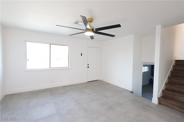 empty room with stairs, ceiling fan, visible vents, and baseboards