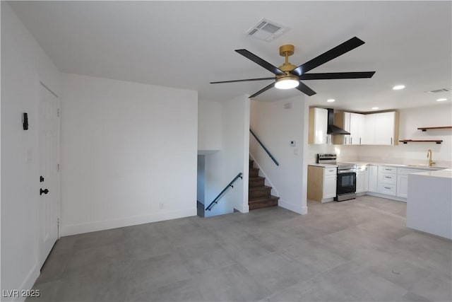 interior space featuring open shelves, visible vents, open floor plan, stainless steel electric range oven, and wall chimney exhaust hood