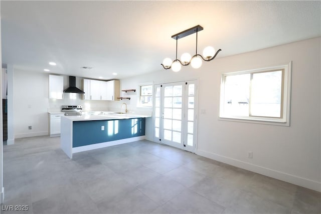 kitchen featuring plenty of natural light, white cabinets, stainless steel electric range oven, and wall chimney exhaust hood