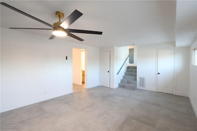 spare room featuring stairway, baseboards, visible vents, and a ceiling fan