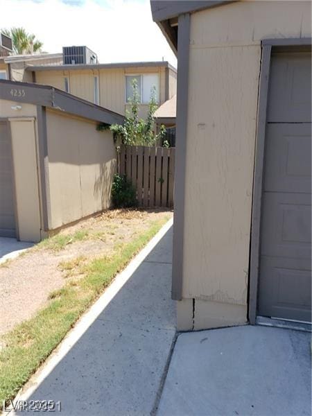 view of property exterior with central AC unit and fence