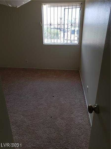 carpeted spare room with lofted ceiling