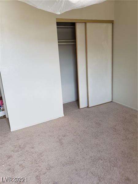 unfurnished bedroom featuring carpet floors and a closet