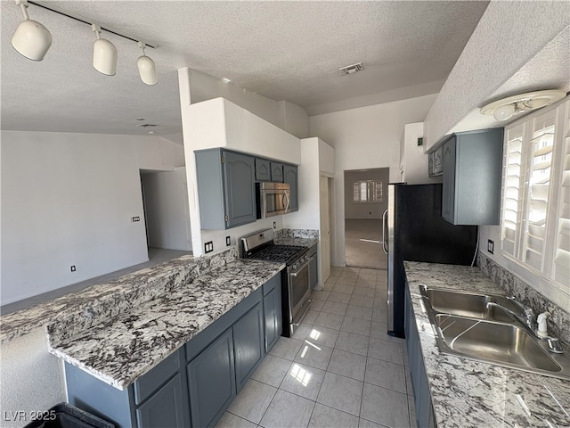 kitchen featuring light tile patterned floors, stainless steel appliances, visible vents, a sink, and a peninsula