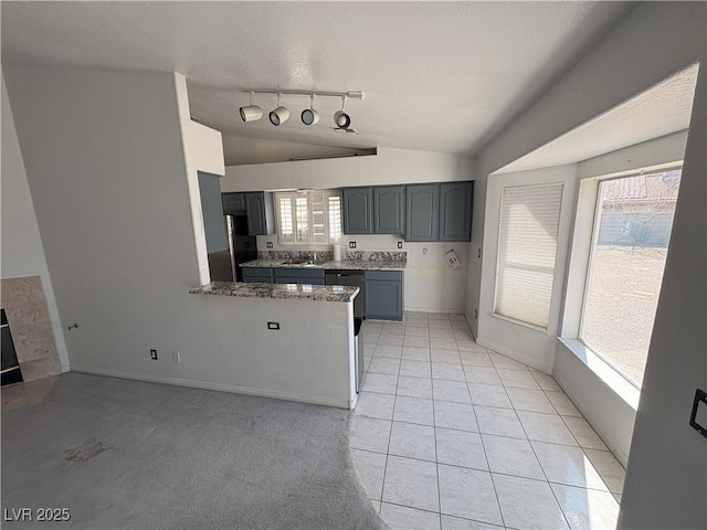 kitchen with lofted ceiling, a textured ceiling, gray cabinetry, refrigerator, and a peninsula