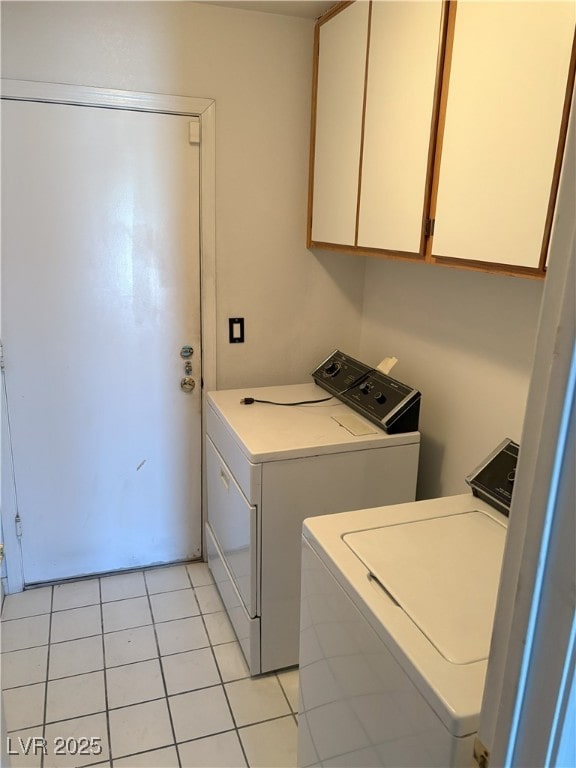 laundry area featuring cabinet space, washing machine and dryer, and light tile patterned floors