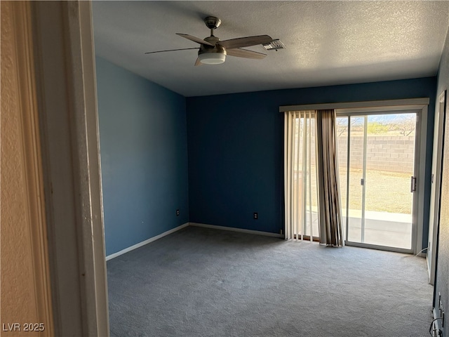 carpeted empty room featuring a textured ceiling, a ceiling fan, and baseboards